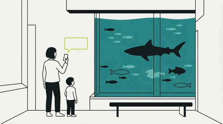 A visitor and child at an aquarium viewing window, asking a question on a phone